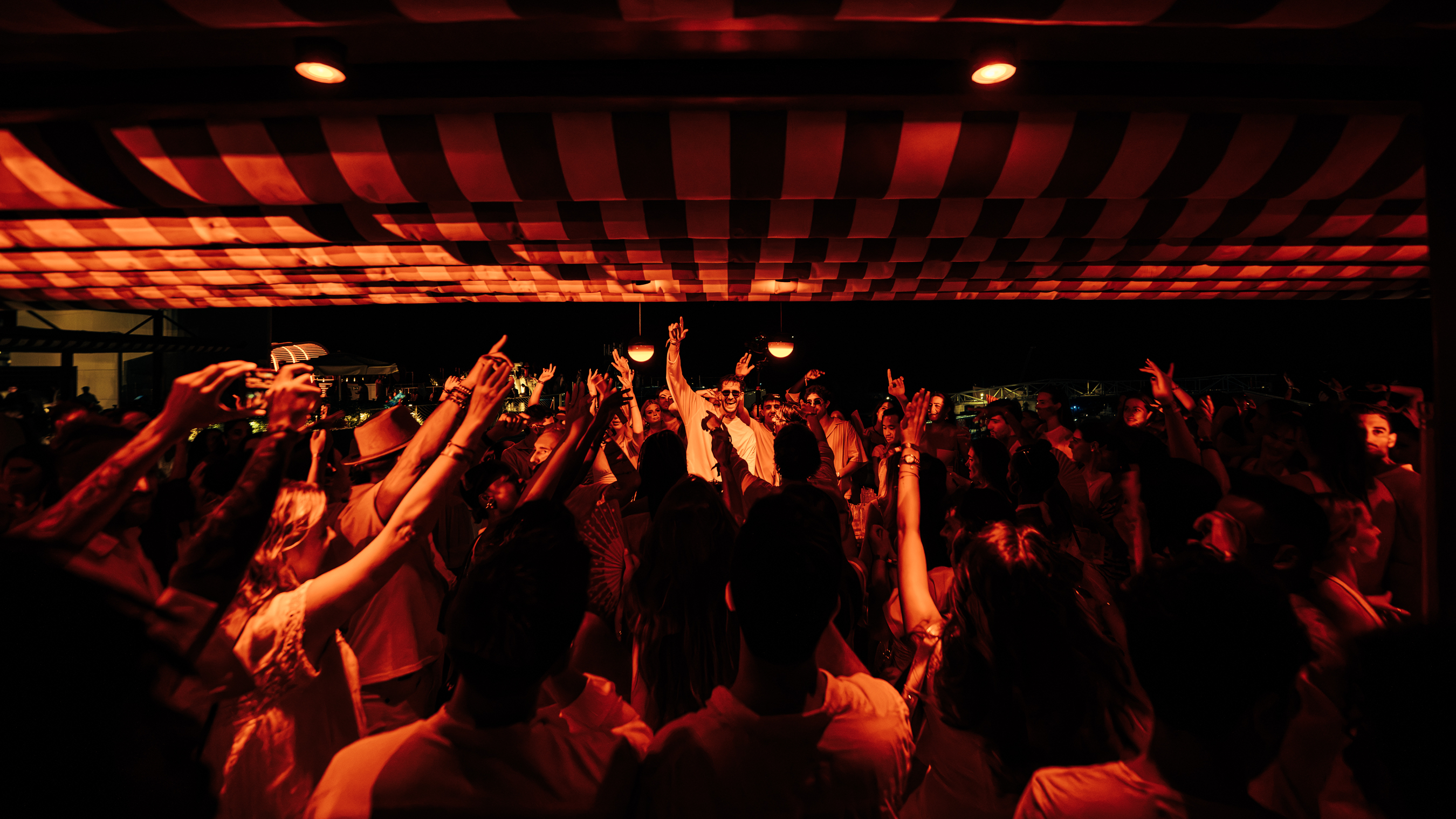 Crowd dancing beneath the canopy during a NOTJUST performance